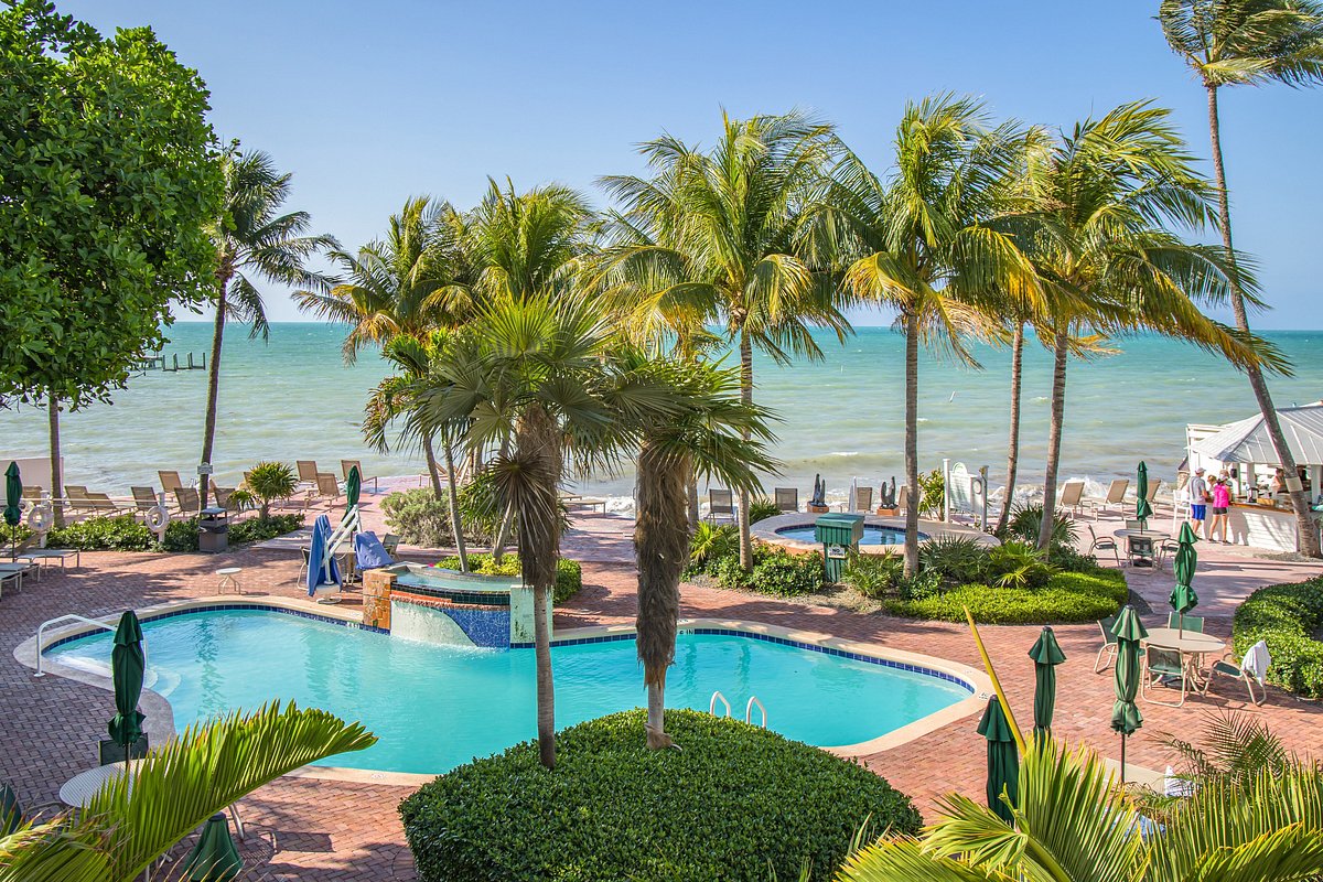 Luxury Key West hotel pool overlooking a sandy beach and turquoise ocean water