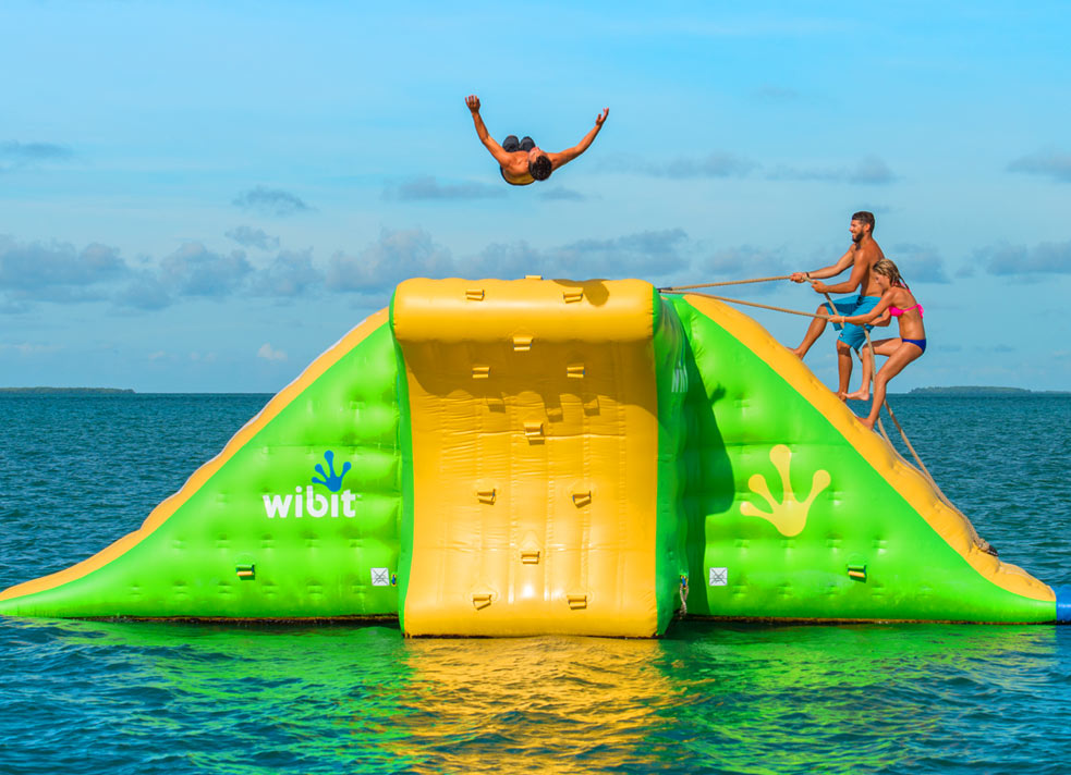 People playing on water slide in ocean